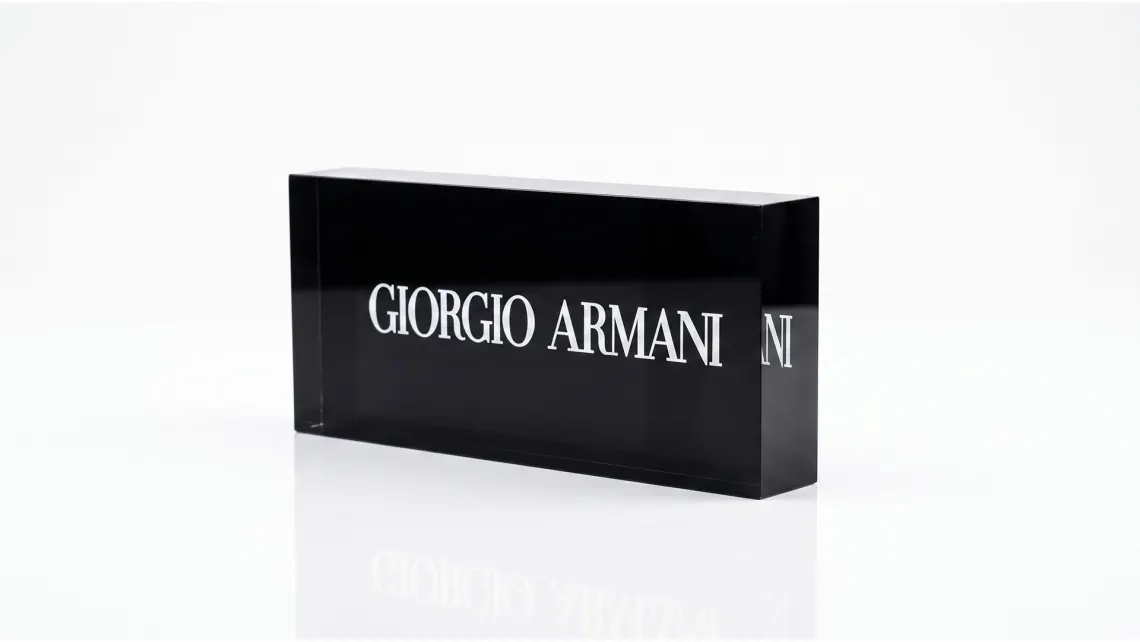 Black acrylic brand block engraved with a logo